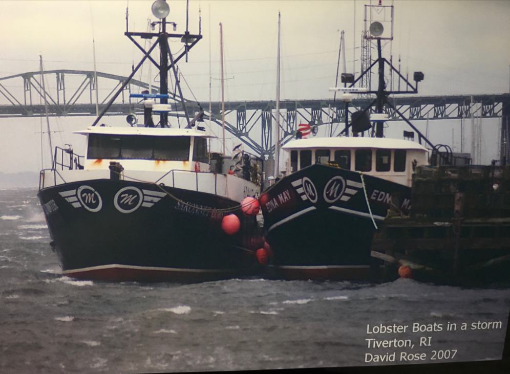 Two lobster boats riding out a storm at a Tiverton pier beneath the Sakonnet River Bridge